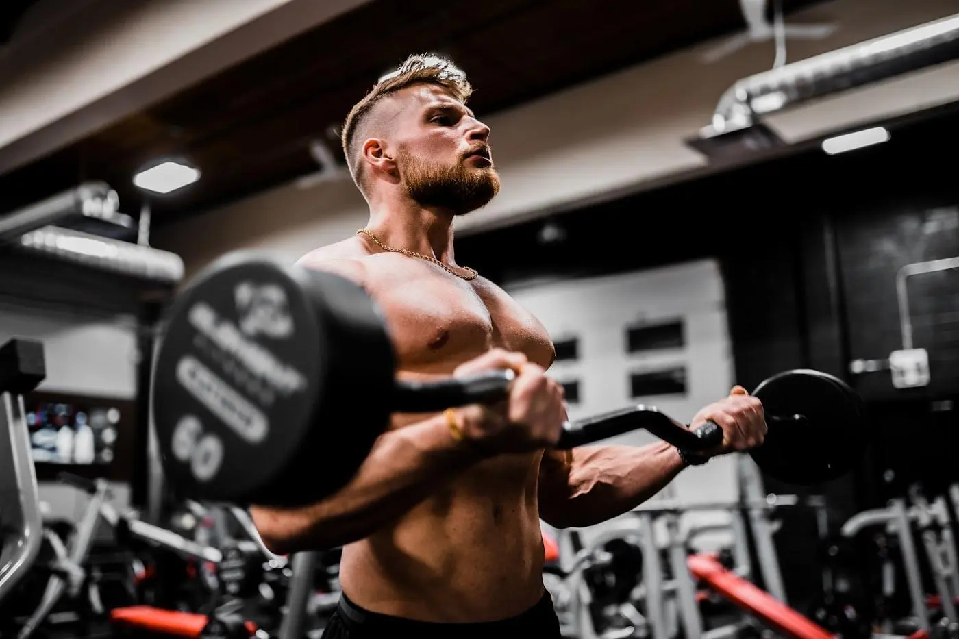 A man doing exercise with Loaded barbell in a gym.
