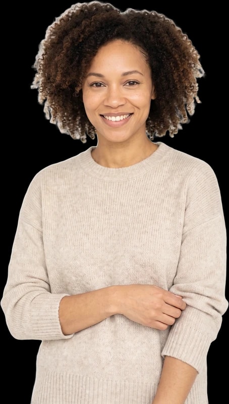 Woman with curly hair in a knit sweater smiling warmly