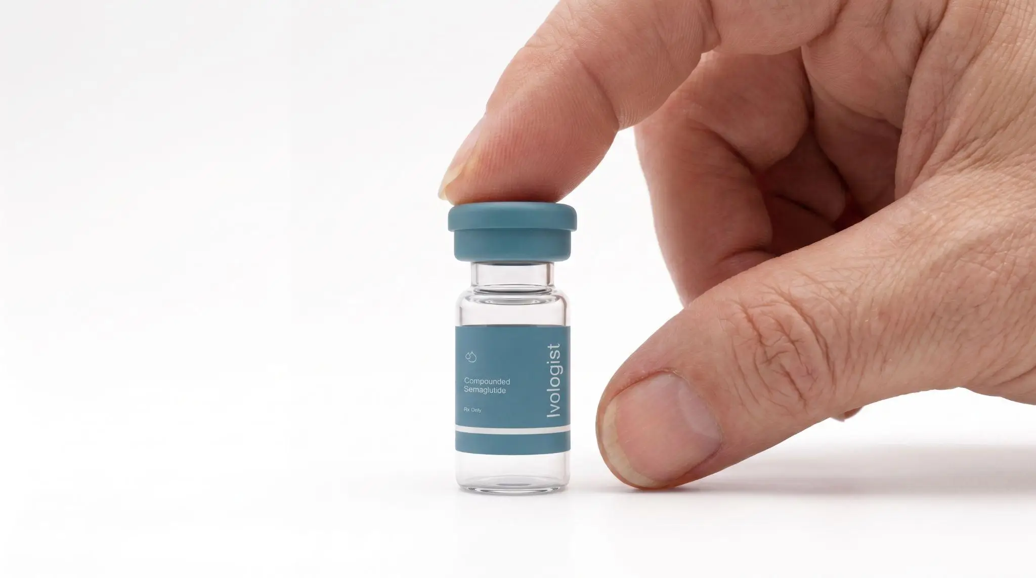 A hand holding a vial of compounded semaglutide